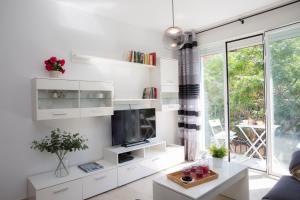 瓦伦西亚霍尔达纳单身公寓的客厅配有白色的架子和电视