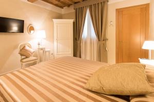 佛罗伦萨迈凯实蓬腾南尼公寓的一间卧室配有一张大床、椅子和窗户