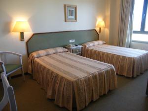 卡斯佩Hotel Magallón的酒店客房,配有两张床和椅子