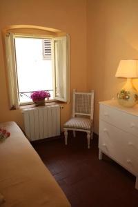 蒙特卡蒂尼泰尔梅吉尔迪穆拉旅馆的一间卧室设有一张床、一个窗口和一把椅子