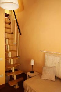 蒙特卡蒂尼泰尔梅吉尔迪穆拉旅馆的一间卧室设有一张床和一个螺旋楼梯