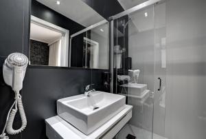 萨拉戈萨皮拉尔广场酒店的浴室配有白色水槽和淋浴。