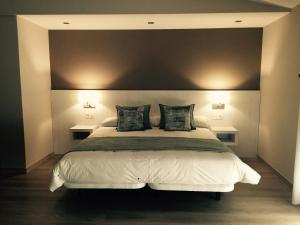 里博雷多Hotel Mirador Ría de Arosa的卧室配有一张带两张桌子的大型白色床