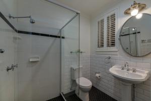 布里斯班Edward Lodge New Fam的一间带卫生间、水槽和镜子的浴室