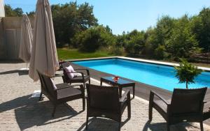 圣托·蒂尔索Equinaturi的游泳池配有椅子、遮阳伞和桌子