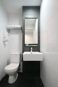 新加坡Value Hotel Balestier的一间带卫生间、水槽和镜子的浴室