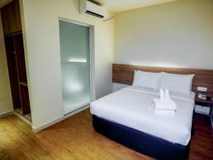 关丹卢舍那客房酒店的卧室配有一张白色大床