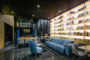 利贝雷茨皮特劳恩帝国大酒店的一个带蓝色沙发和书架的图书馆