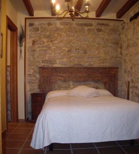 埃斯皮诺萨德洛斯蒙特罗斯Hotel Rural La Casa del Montero的一间卧室配有一张石墙床