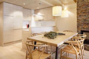 巴奎伊拉-贝莱特Val de Ruda Luxe 41 by FeelFree Rentals的厨房以及带木桌和椅子的用餐室。