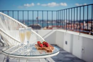 里斯本希亚多阿尔梅利亚珍藏公寓的阳台上的玻璃桌,配有2杯玻璃杯和草莓