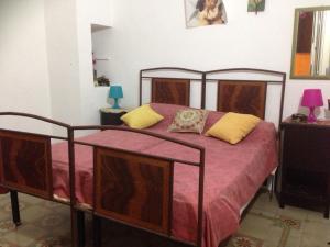 库特罗菲安诺Nel Cuore del Salento的一间卧室配有红色床单和黄色枕头。