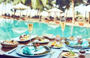 尼甘布杰特维茵酒店集团有限公司的餐桌,带食物盘和香槟杯