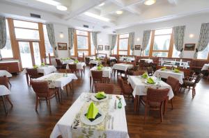 罗斯诺夫·波德·拉德霍斯滕活力康体度假酒店的餐厅设有白色的桌椅和窗户。