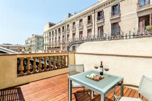 巴塞罗那埃克兰布拉斯博科瑞雅酒店的阳台上的桌子和两杯葡萄酒