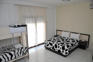 都拉斯Sunrise Hotel Cameria的卧室设有黑白床和窗户。