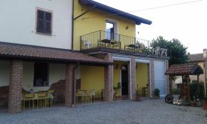 Francavilla BisioAgriturismo Il Vecchio Portico的黄色和白色的房子,配有桌子和椅子