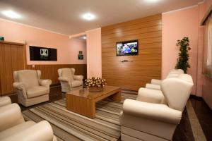 圣卡洛斯Indaiá Hotel Residence的一间设有椅子和墙上电视的等候室