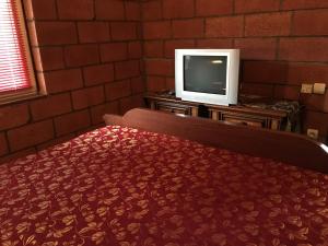塞凡Lavanda City的一间卧室配有一张床和一张桌子上的电视