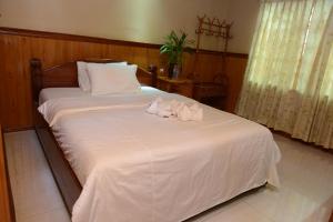 Tbeng Meanchey哈维尔旅馆的一间卧室配有一张床,上面有两条毛巾