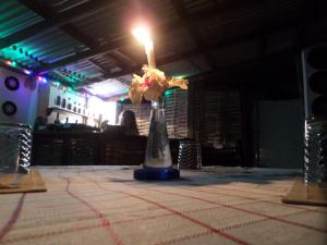 安东尼奥港La Familia Guest House and Natural Farm的一张桌子上放着蜡烛的花瓶