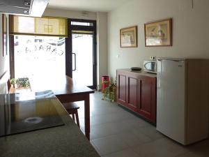 拉林Hostal Caracas的带冰箱和桌子的厨房