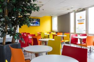 鲁瓦西昂法兰西Premiere Classe Roissy Aéroport Charles De Gaulle的色彩鲜艳的自助餐厅,配有桌椅