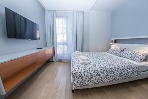 索波特LoveSopot Luxury Terrace Apartment的一间卧室配有一张床和一台平面电视