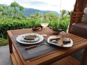 萨玛拉Hotel Peace & Lodge的一张桌子,上面放着一盘食物和一杯葡萄酒