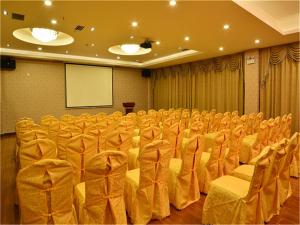 武汉麗枫酒店·武汉高铁店的一个带椅子、讲台和屏幕的会议室