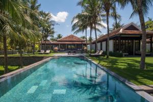 会安越南会安南海四季度假酒店的棕榈树屋前的游泳池
