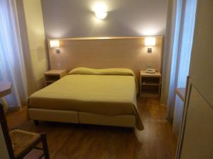 斯特雷萨大切萨雷酒店的一间卧室配有一张大床和两张桌子