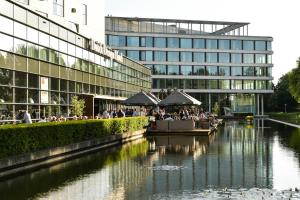 阿姆斯特丹阿蒂米斯荷兰设计酒店的一群人坐在河边的桌子旁