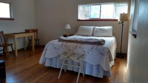 星期五港Jones Cabin的一间卧室配有一张桌子和两个窗户。