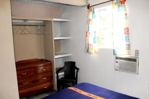 圣萨尔瓦多西梅纳斯宾馆的一间卧室配有一张床、一个梳妆台和一扇窗户。