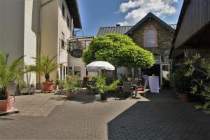 诺伊马根-德赫龙Weingut Koch的建筑前方种有盆栽植物的庭院