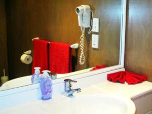 拉罗汤加Muri Beach Hideaway - Adults Only的一间带镜子和电话的盥洗盆的浴室