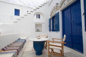帕诺尔莫斯Ioanna's的一个带桌椅的庭院和一扇蓝色的门