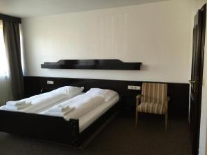 洪堡西贡酒店的两张位于酒店客房的床 - 带椅子