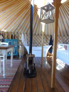 CatignanoGlamping Abruzzo - The Yurt的圆顶帐篷内的炉灶,配有桌子和床