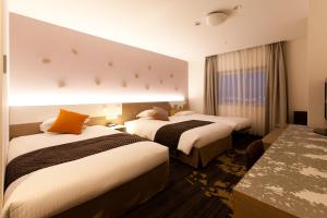 富山东急富山卓越大酒店的酒店客房设有两张床和窗户。