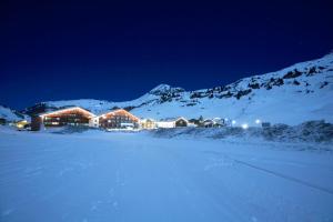 祖尔斯ROBINSON ALPENROSE Zürs的雪中小屋,雪覆盖着群山