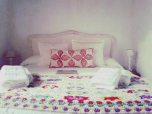 巴拉德瓦利扎斯Posada Valizas的一张白色的床,上面有一条钩编毯子