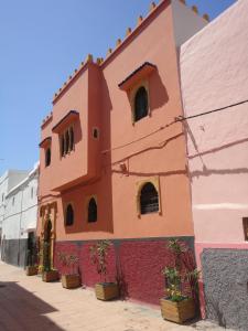 拉巴特达尔亚尼斯旅馆的一座建筑,上面有红色和粉红色的油漆