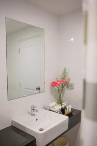 普吉镇康内斯特公寓式酒店的浴室设有白色水槽和镜子