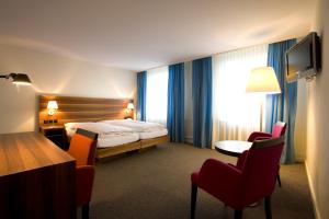 奥尔滕阿斯托利亚酒店的酒店客房带一张床、一张桌子和椅子