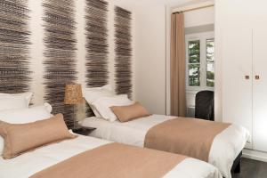 沙特尔Les Toits de Chartres - 2 appt - Parking gratuit的配有白色墙壁的酒店客房内的两张床