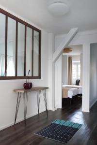 沙特尔Les Toits de Chartres - 2 appt - Parking gratuit的白色的客房设有一张床和一张桌子,上面有苹果