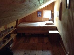 瑟尔沃斯堡Lusthuset的木制客房内的一间卧室,配有一张床