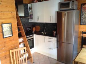 瑟尔沃斯堡Lusthuset的厨房配有白色橱柜和不锈钢冰箱